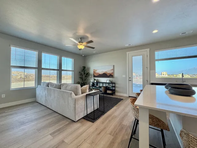 Living area with ceiling fan, light wood-style floors, a textured ceiling, and recessed lighting