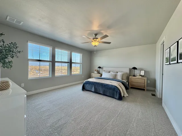 Bedroom featuring carpet, ceiling fan, and a textured ceiling