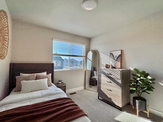 Bedroom with a textured wall, carpet flooring, and a textured ceiling