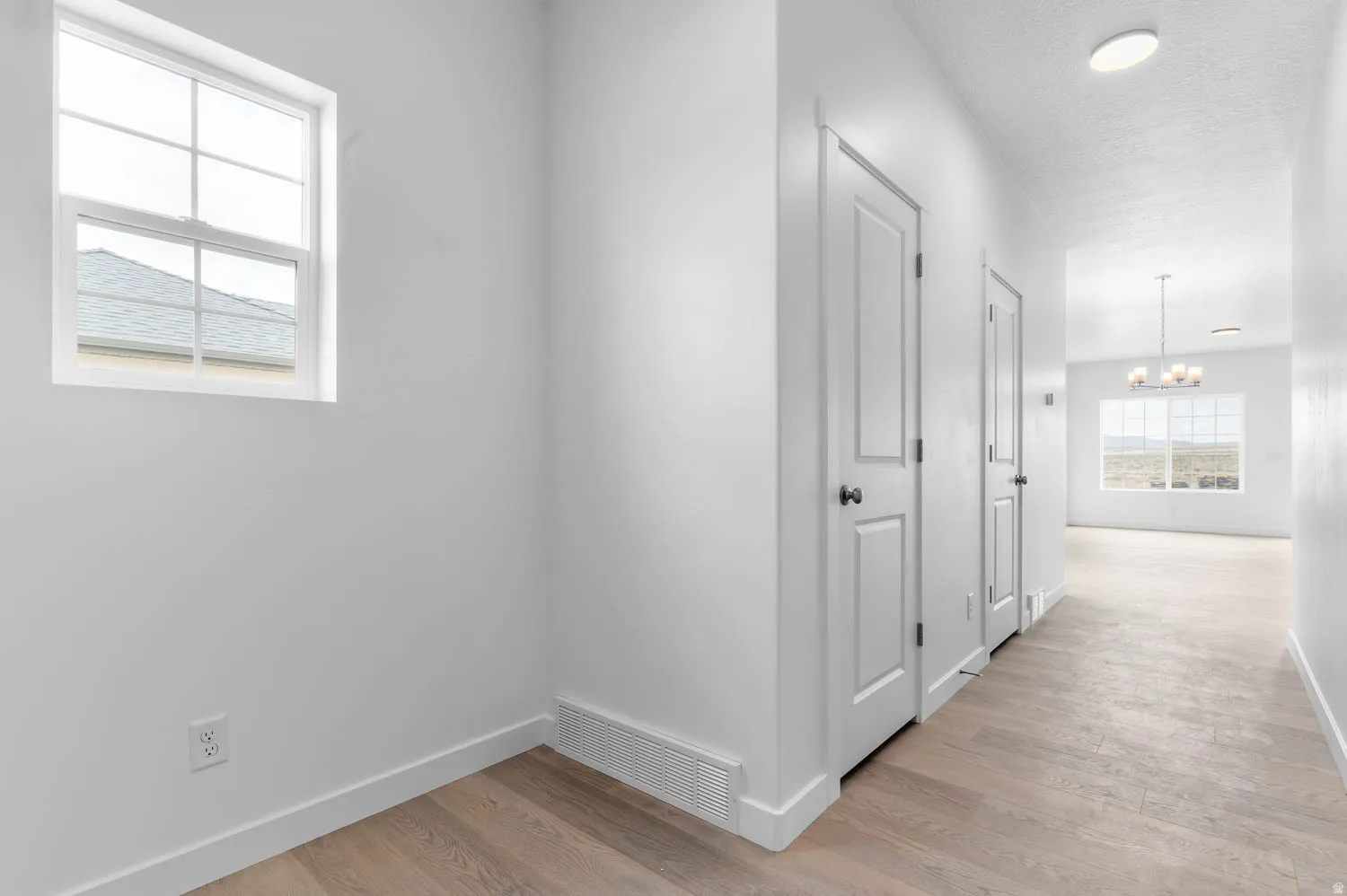 Hallway featuring wood-finish flooring and white baseboards