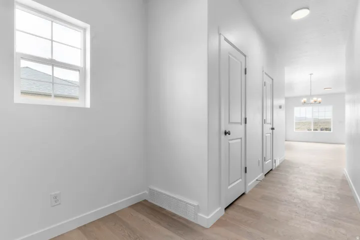 Hallway featuring wood-finish flooring and white baseboards