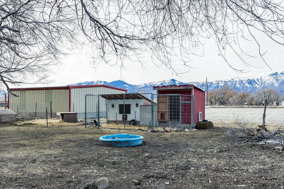 Back of house featuring an outbuilding, a mountain view, and exterior structure