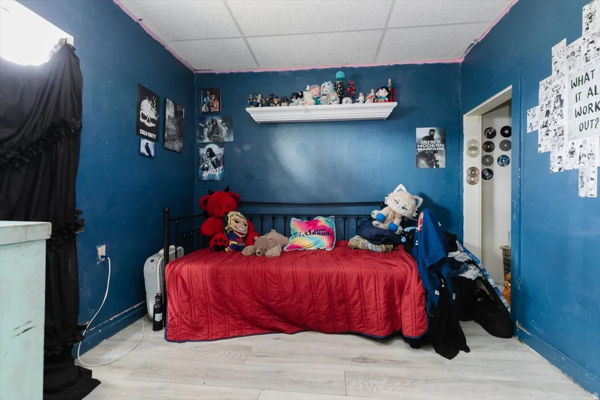 Bedroom with a drop ceiling and wood finished floors