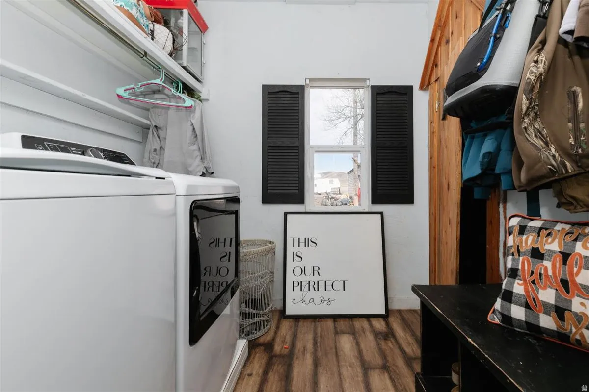 Laundry room with dark wood-style flooring and washing machine and clothes dryer