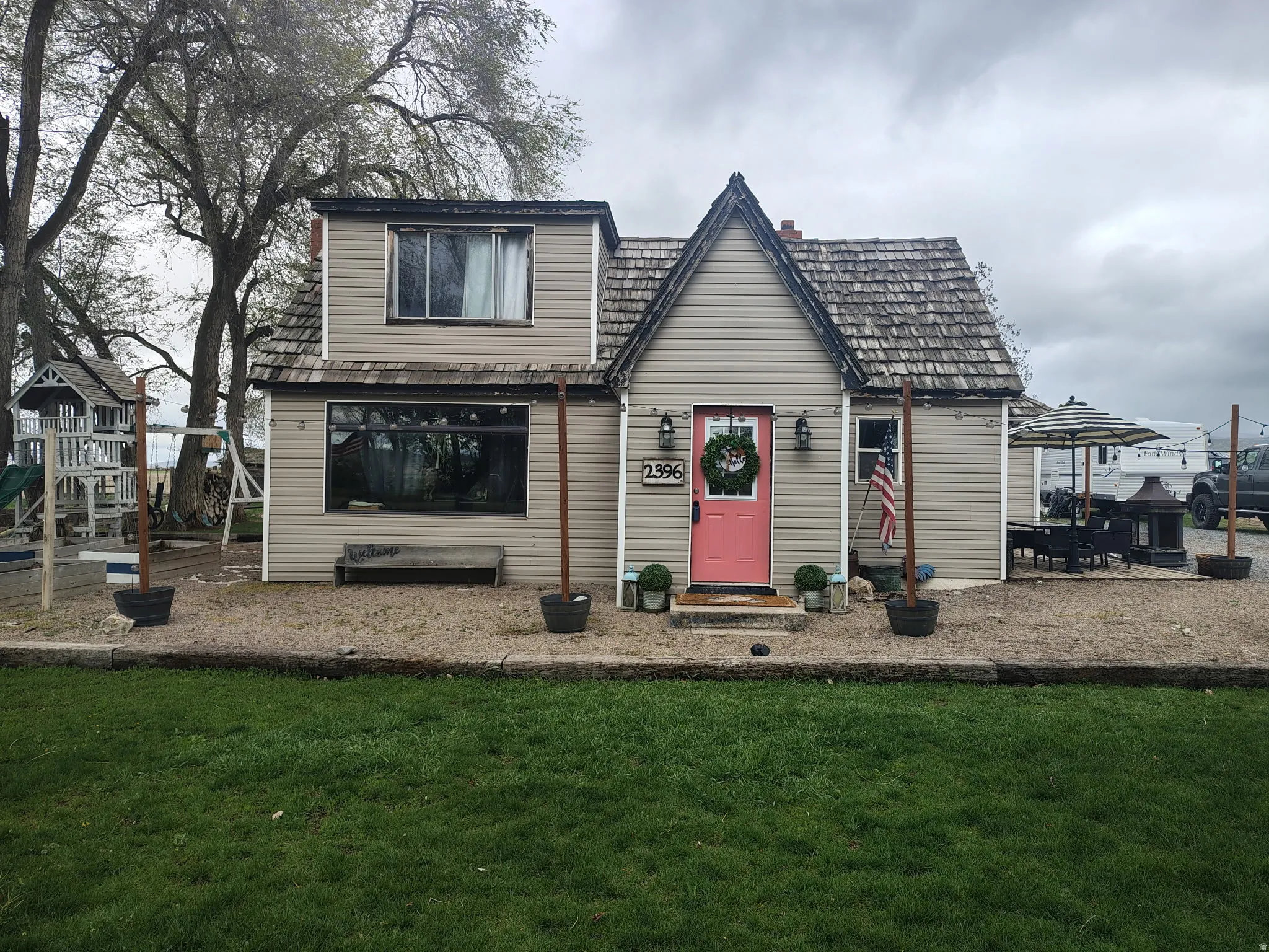 View of front of house with entry steps, a front lawn, a playground, and a chimney