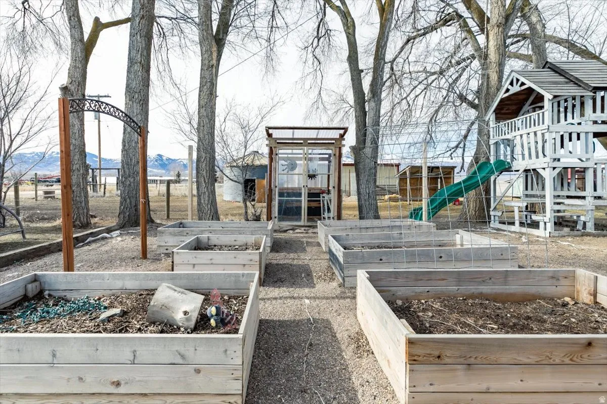 Communal playground featuring an outdoor structure and a vegetable garden
