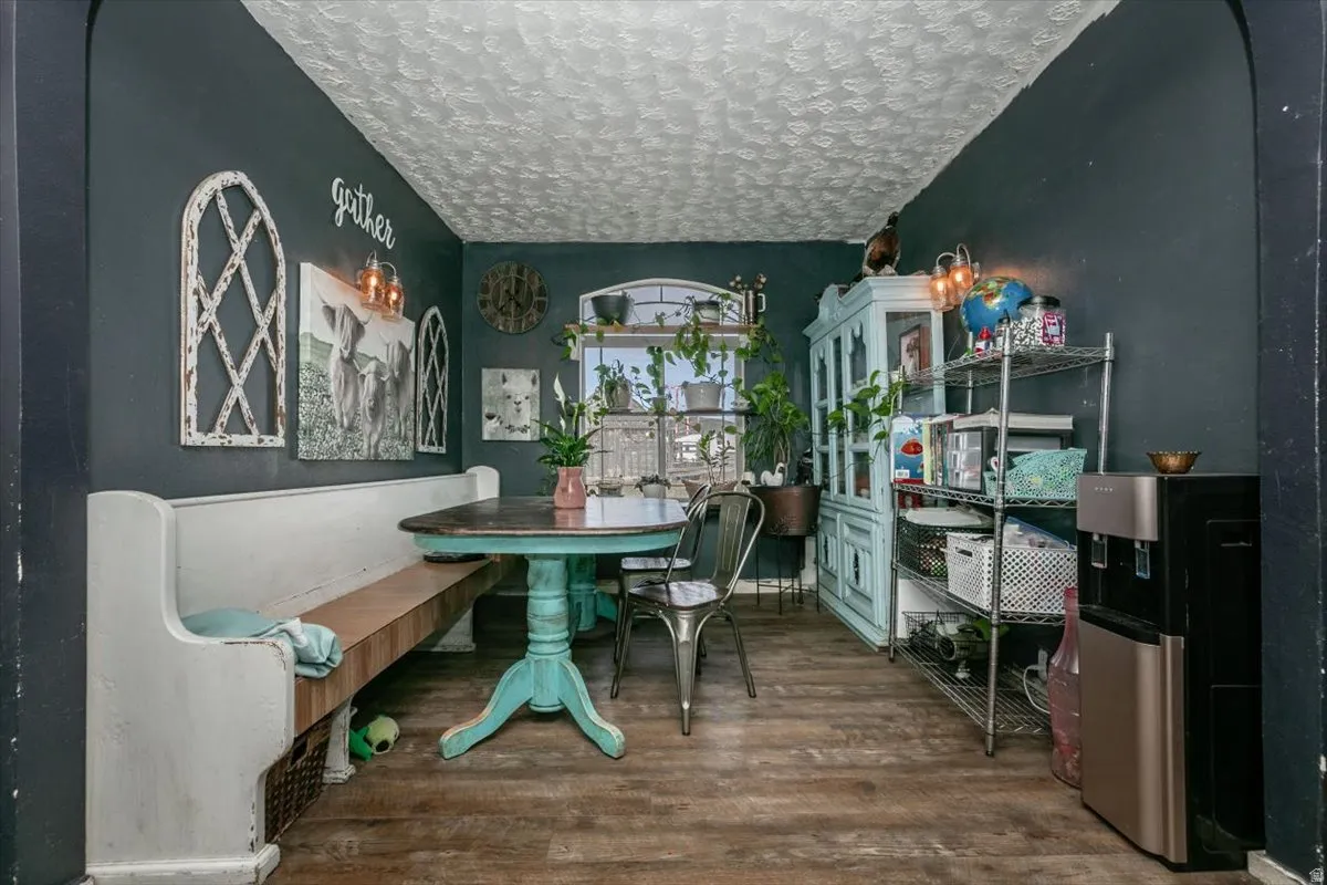 Dining area featuring dark wood-style flooring and a textured ceiling