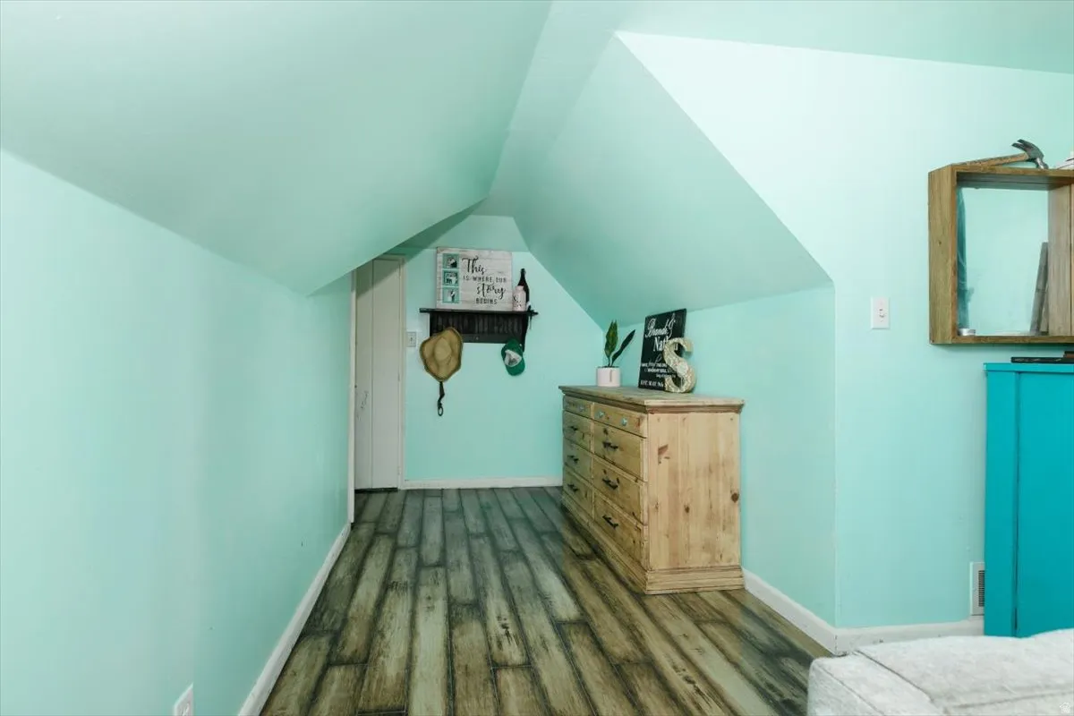Additional living space with lofted ceiling and wood finished floors