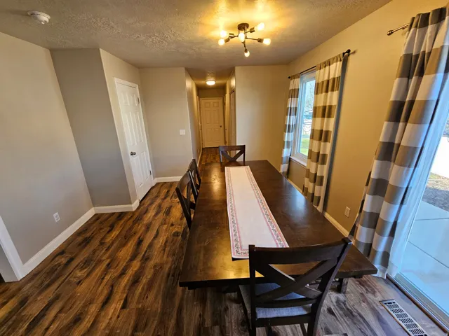 Dining space featuring a textured ceiling and dark wood-style flooring