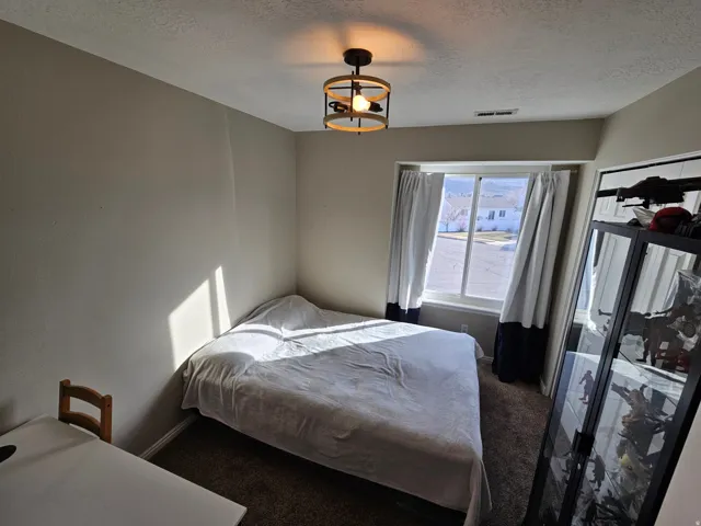 Bedroom with carpet flooring and a textured ceiling