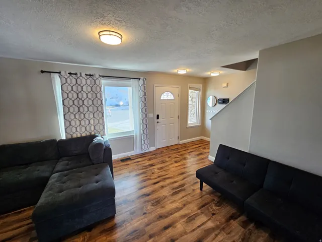 Living room featuring a textured ceiling and wood finished floors