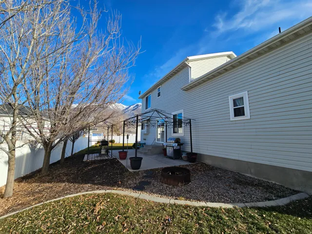 Back of property with a patio area and an outdoor fire pit