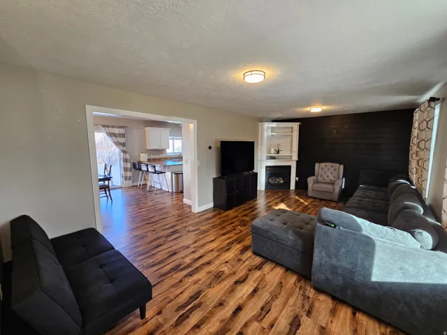 Living room featuring a textured ceiling, a fireplace, and dark wood-type flooring