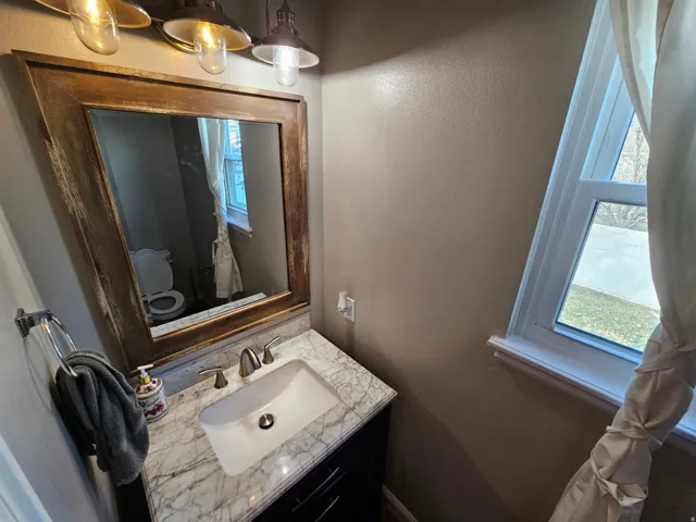 Half bathroom with a textured wall and vanity
