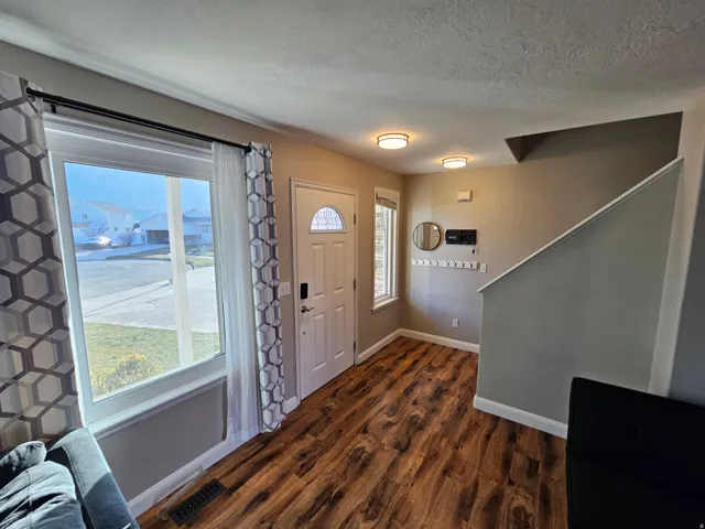 Foyer featuring dark wood-style floors and a textured ceiling
