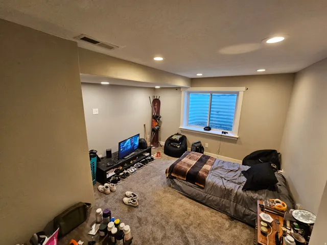 Carpeted bedroom with recessed lighting and a textured ceiling