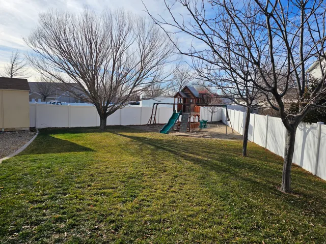 Fenced backyard with a playground