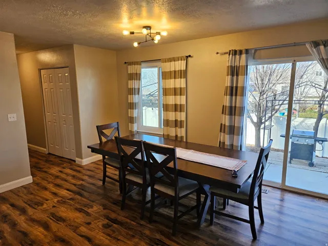 Dining space featuring dark wood-style floors and a textured ceiling