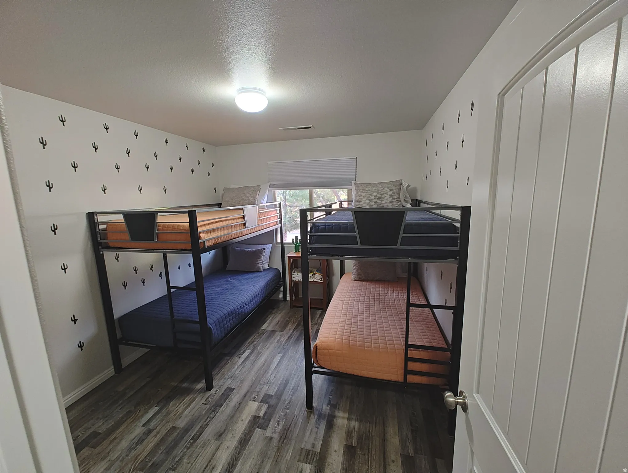Bedroom with dark wood-style flooring and a textured ceiling