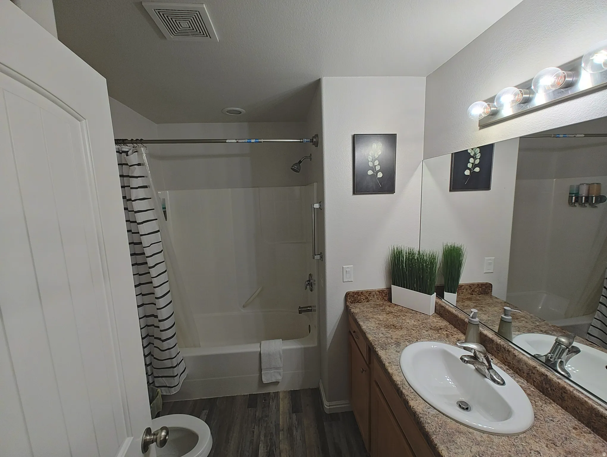 Full Master bathroom featuring shower / bath combination with curtain, vanity, and dark wood-style floors