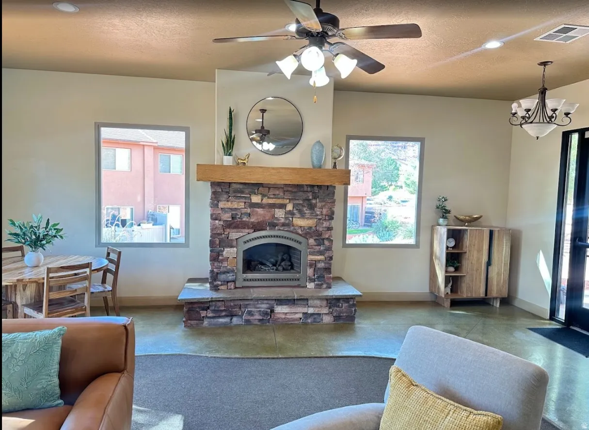 Club house -Living room featuring ceiling fan, a fireplace, a textured ceiling, and recessed lighting