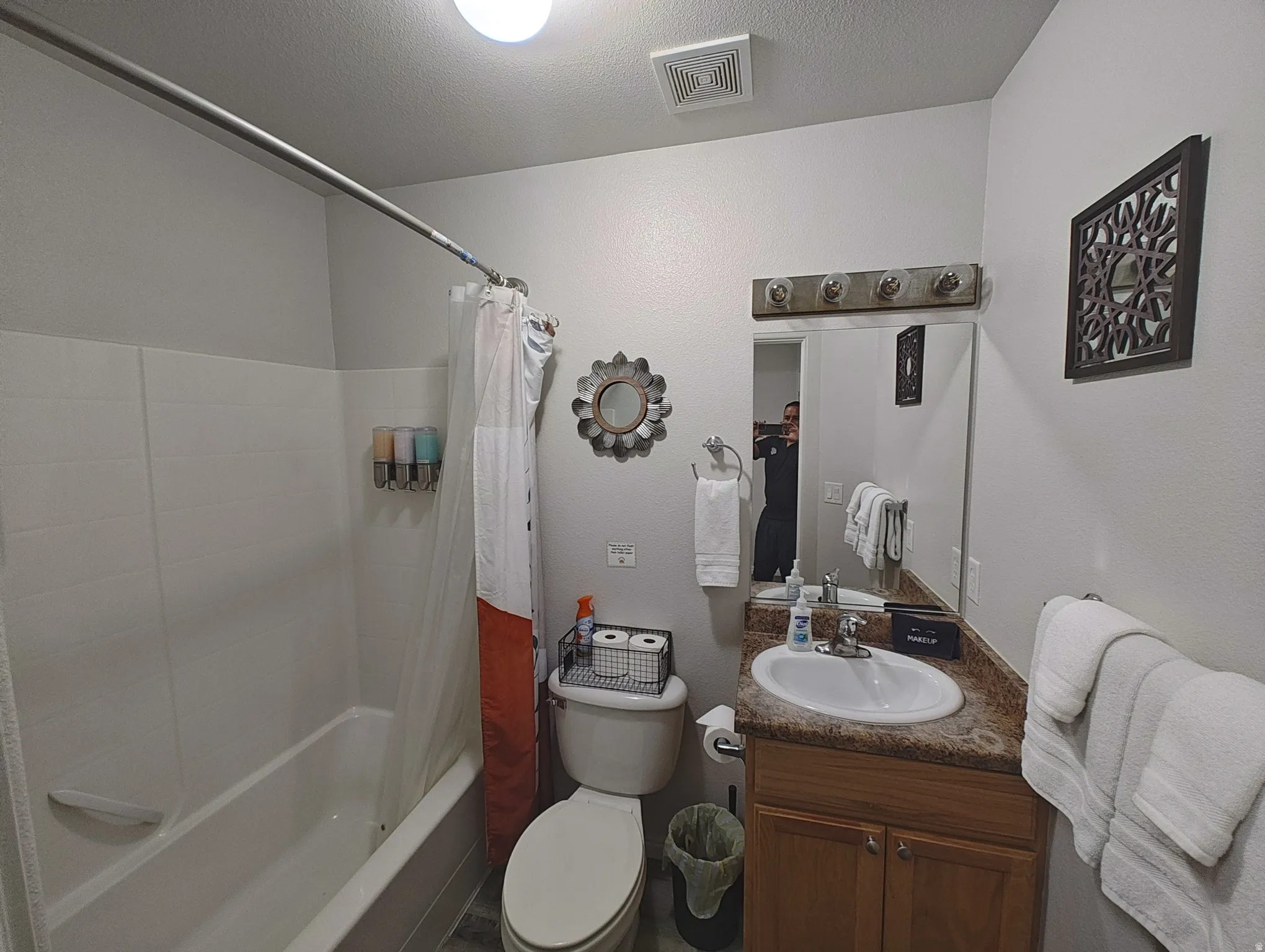Bathroom featuring shower / bathtub combination with curtain, vanity, and a textured ceiling