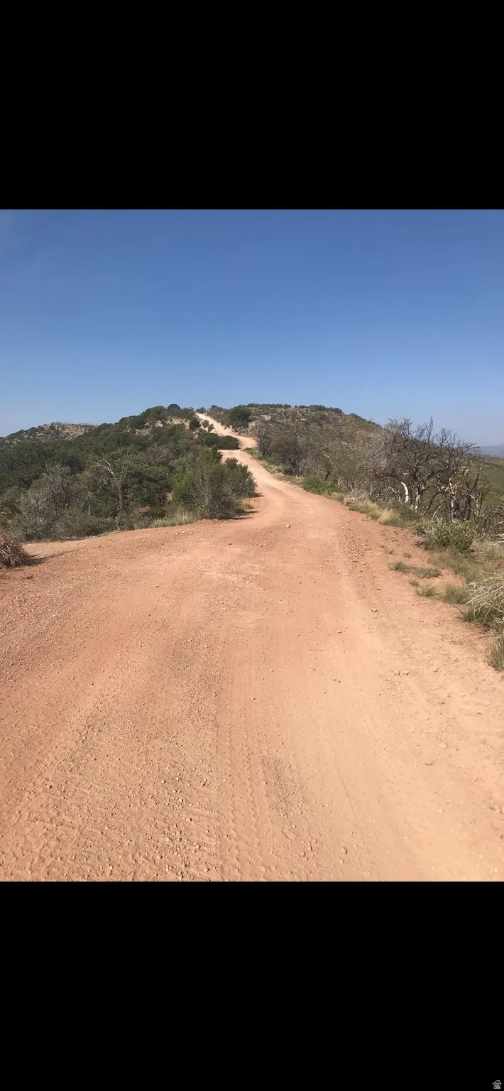 View of dirt / gravel road featuring a mountain view and a rural view