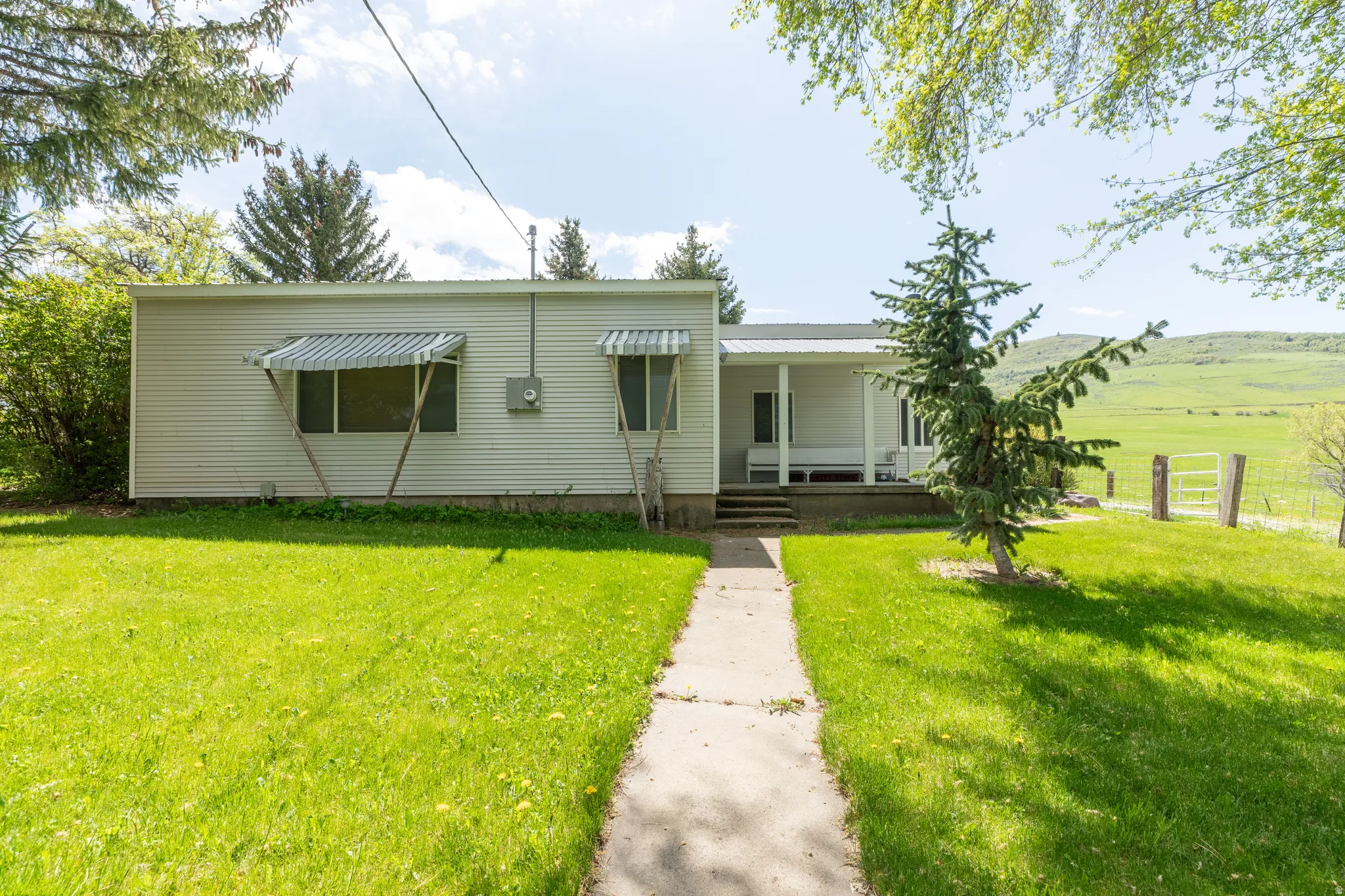 View of front facade featuring a front yard and covered porch