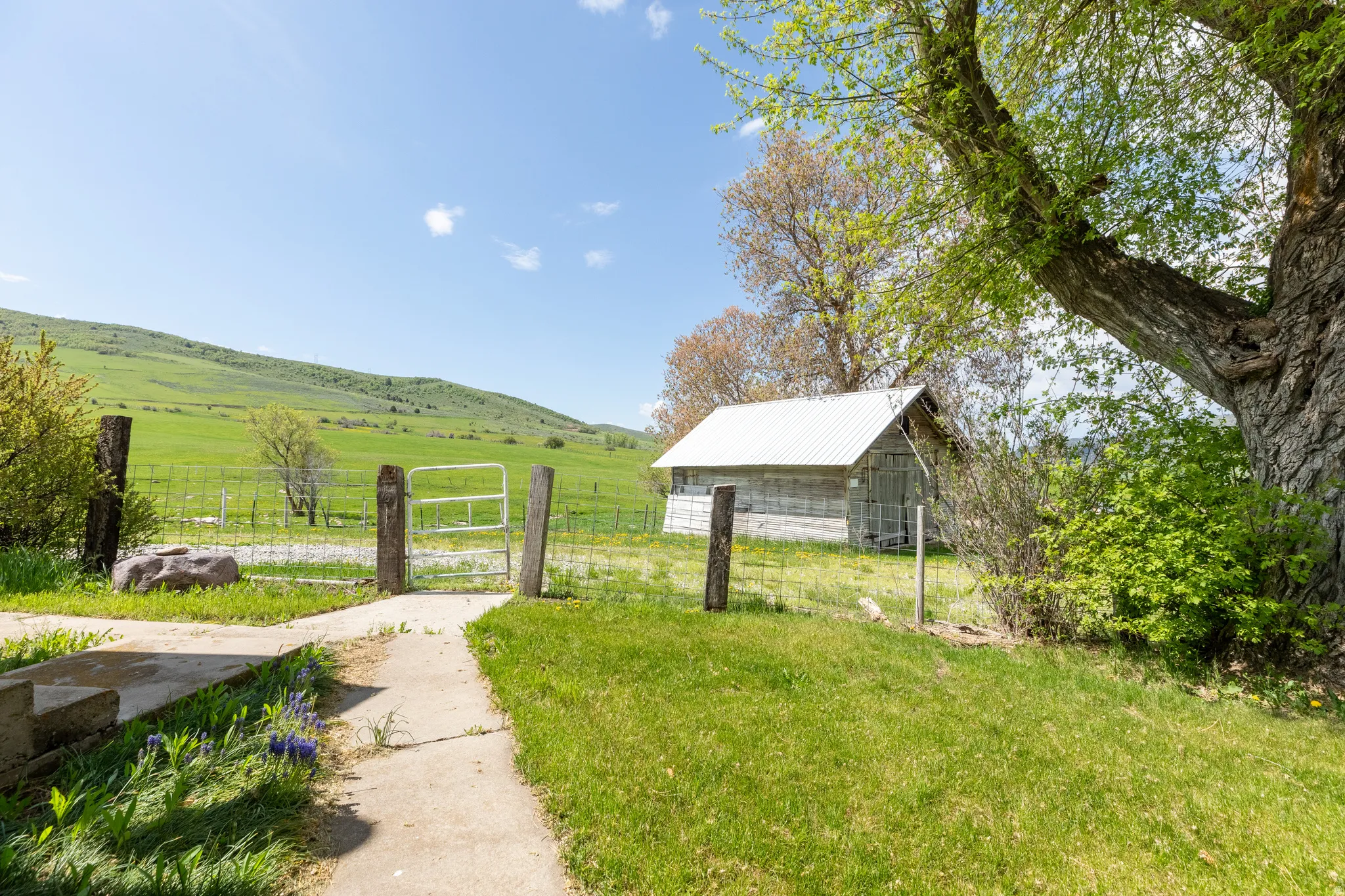 View of yard with a view of rural / pastoral area, an outbuilding, a pole building, and a gate