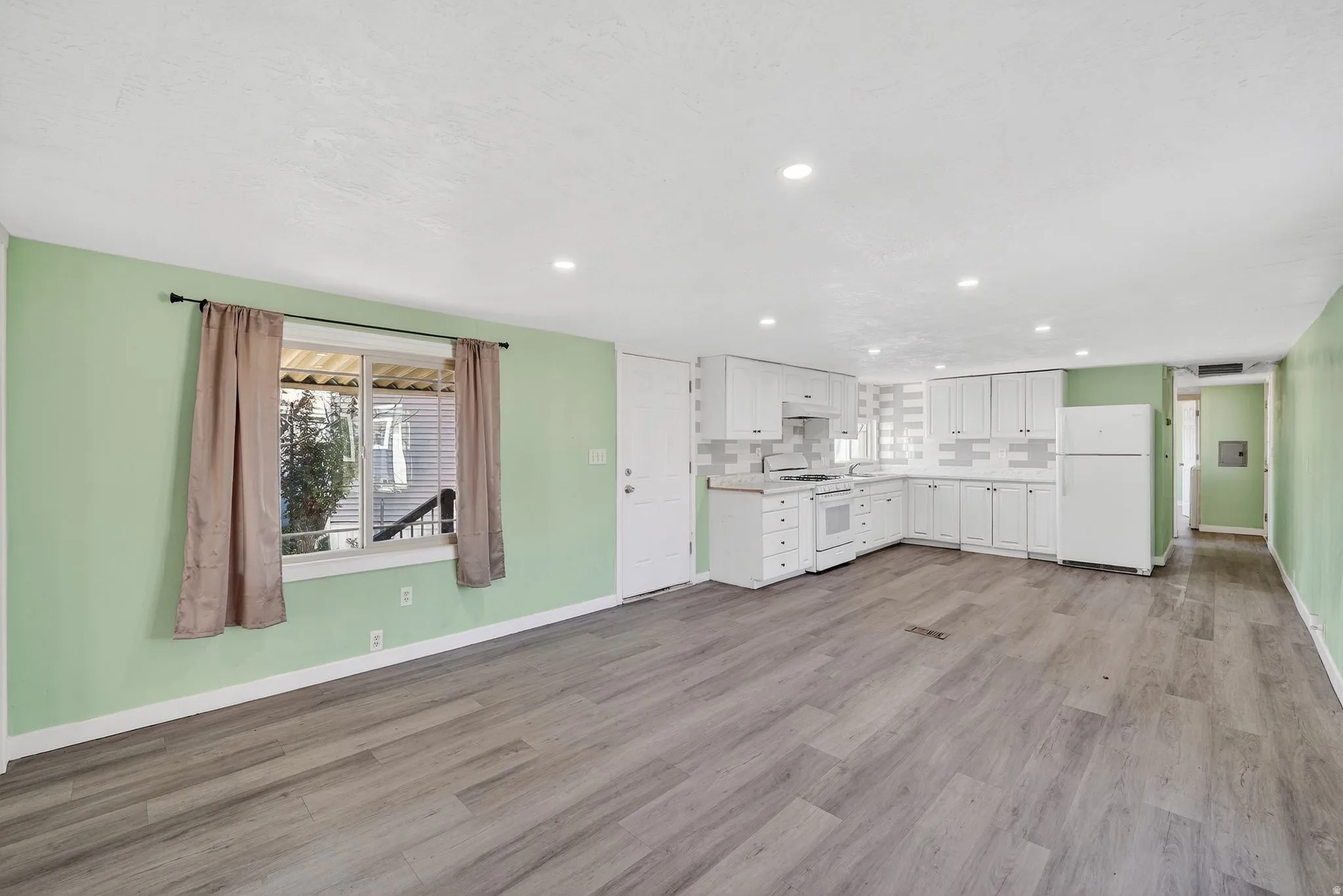 Unfurnished living room featuring light wood-style floors and recessed lighting