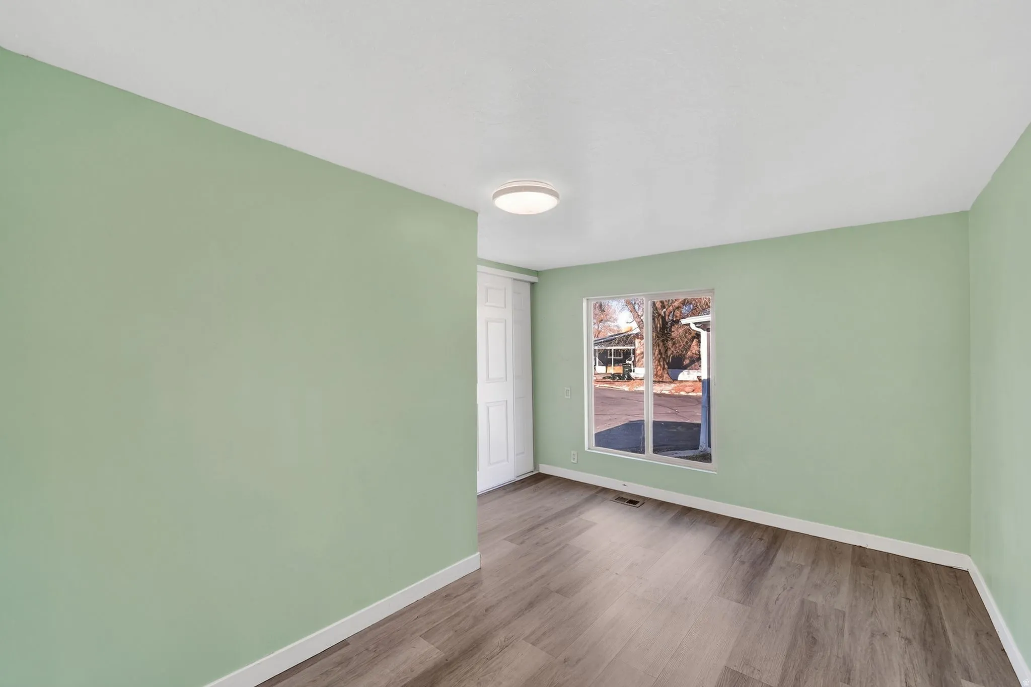 Spare room with baseboards and wood finished floors