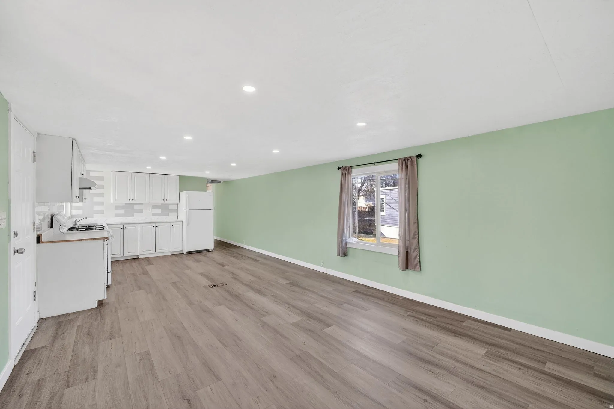 Unfurnished living room with light wood-type flooring and recessed lighting