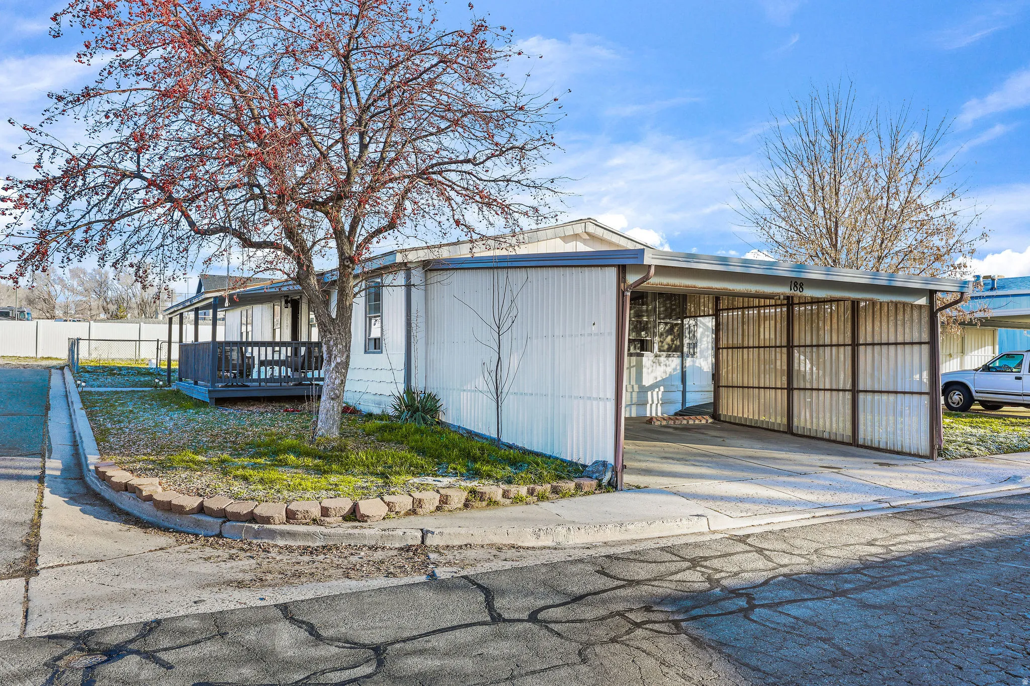 View of home's exterior with driveway, an attached carport, and a wooden deck