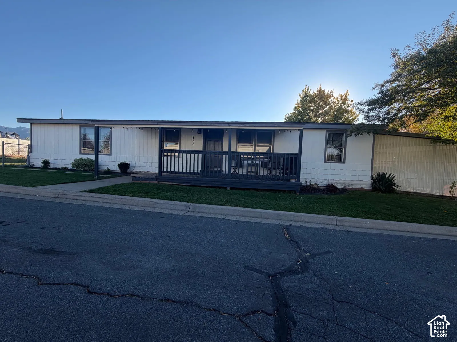 Charming manufactured home featuring a welcoming front entrance with a covered porch, metal siding exterior, and large windows allowing natural light throughout