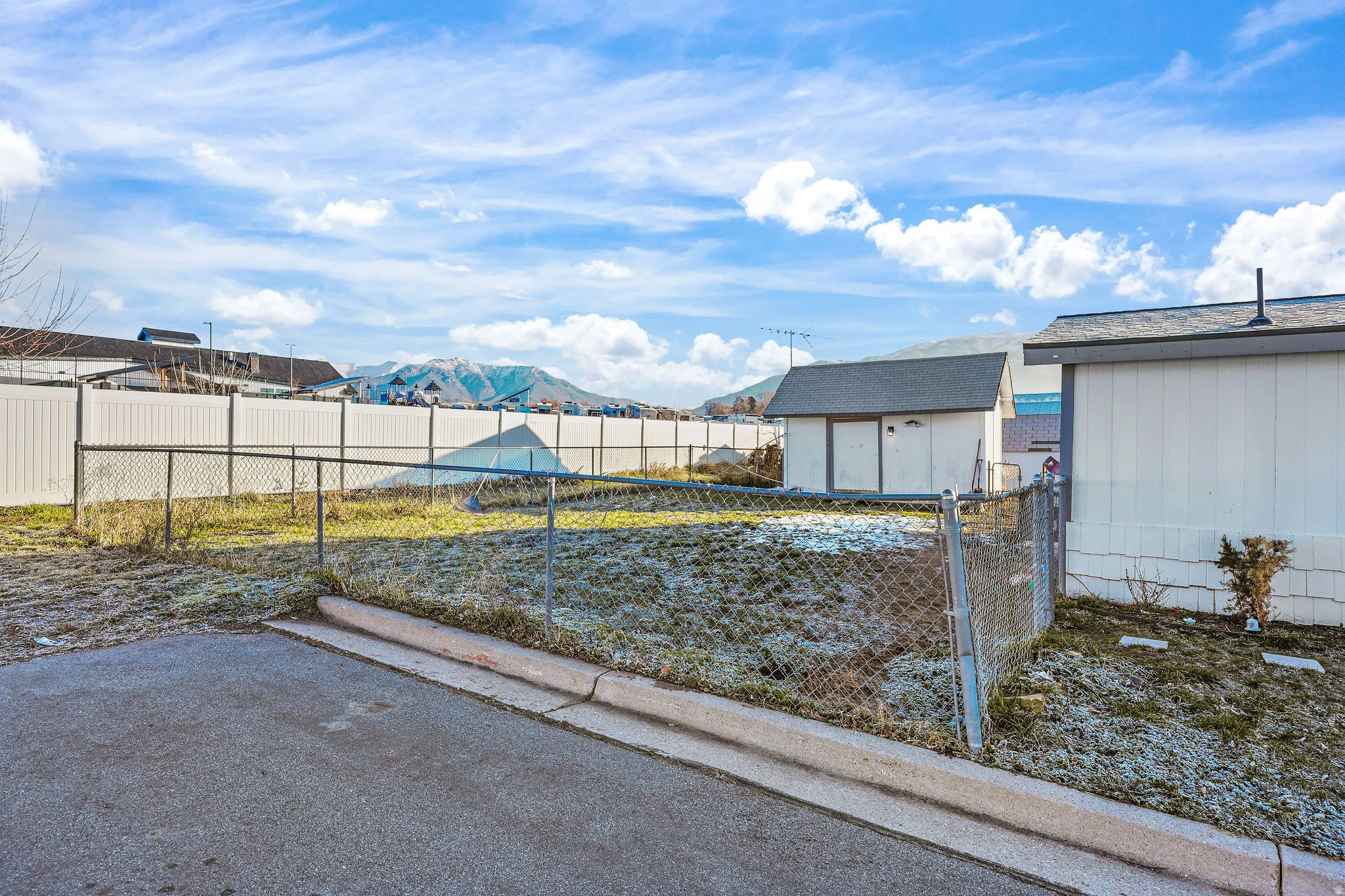 Fenced backyard with a mountain view, a storage shed, and a patio