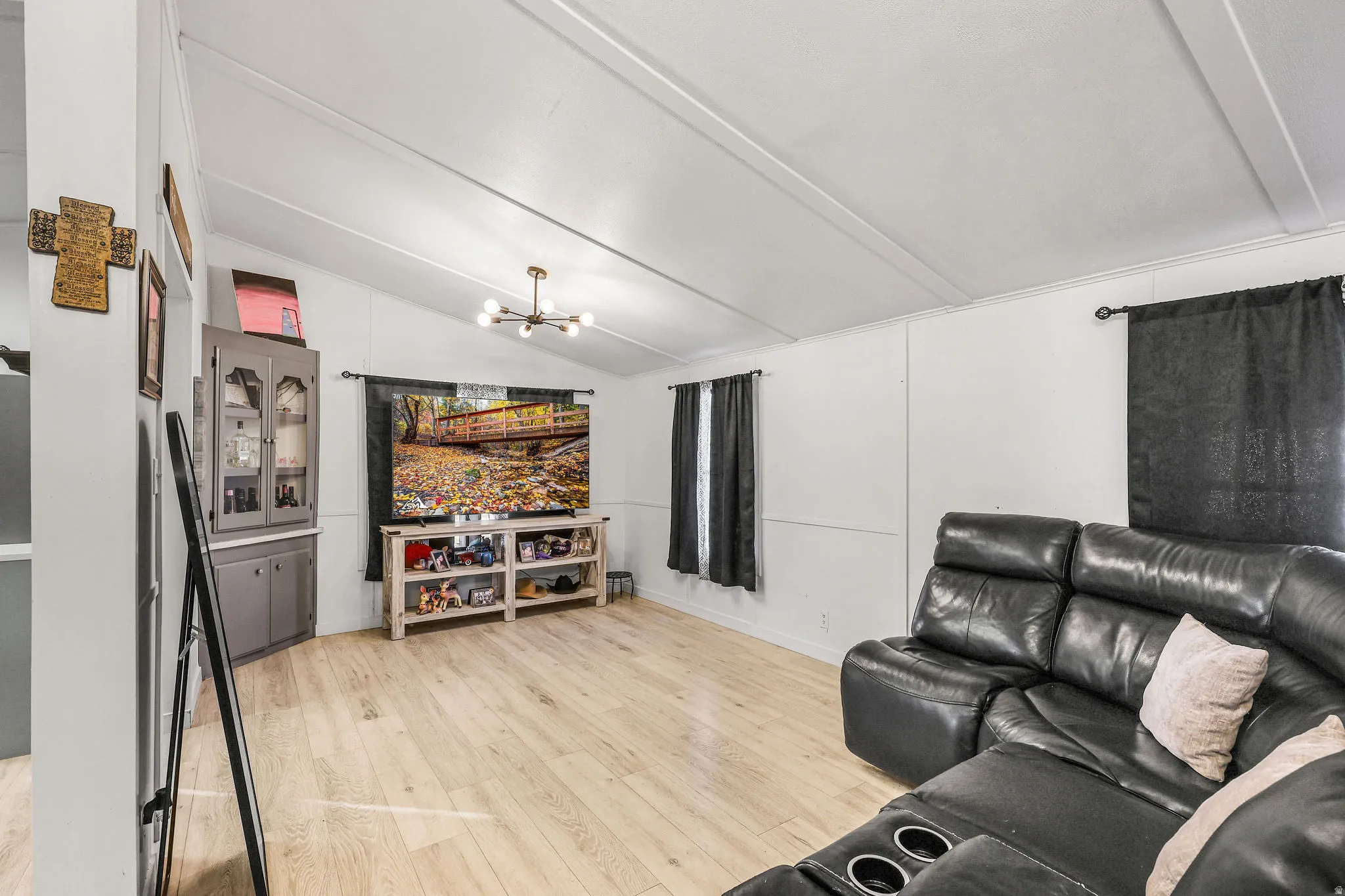 Living area featuring lofted ceiling, a chandelier, and light wood finished floors