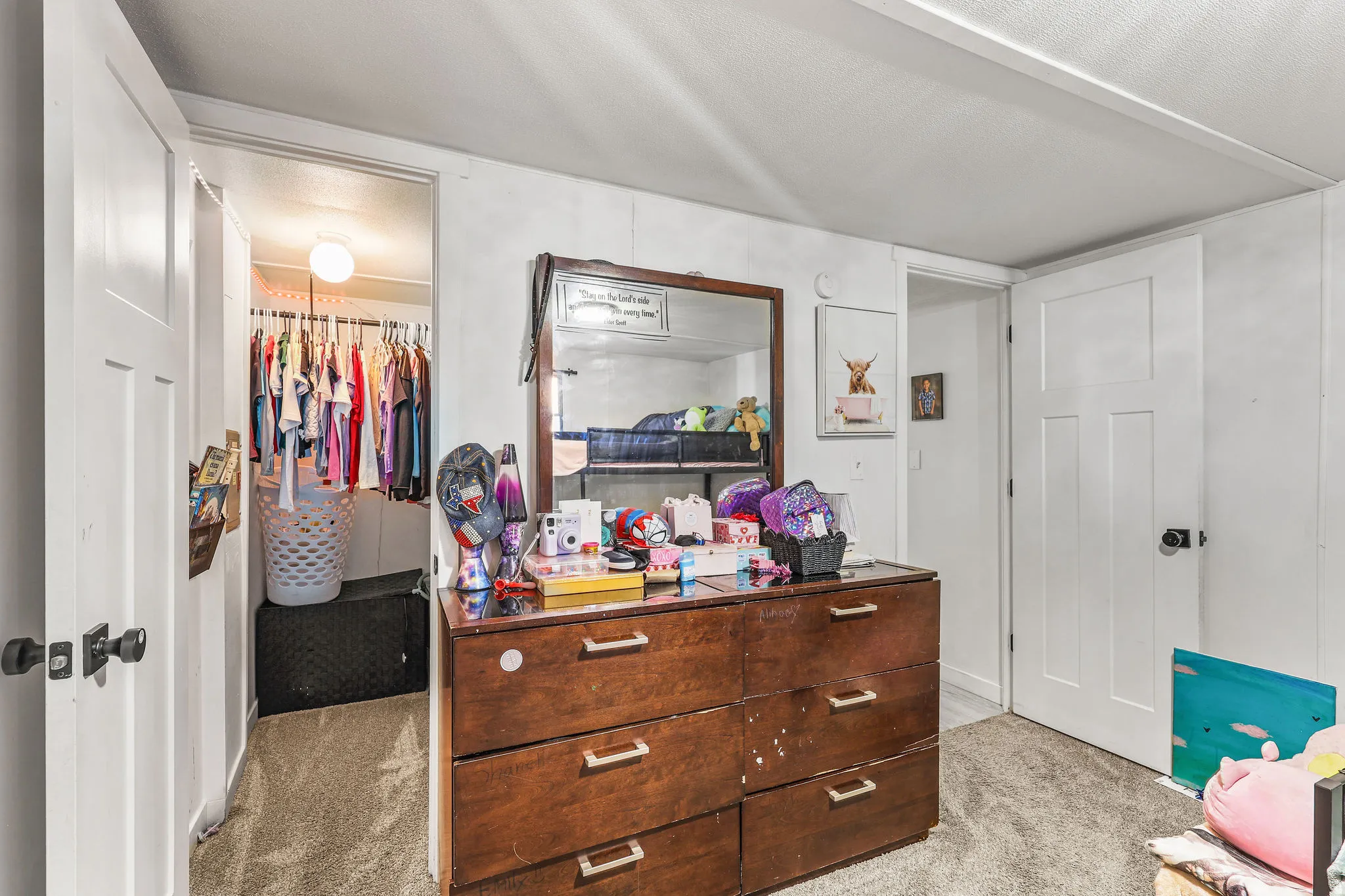 Bedroom featuring light carpet and a walk in closet