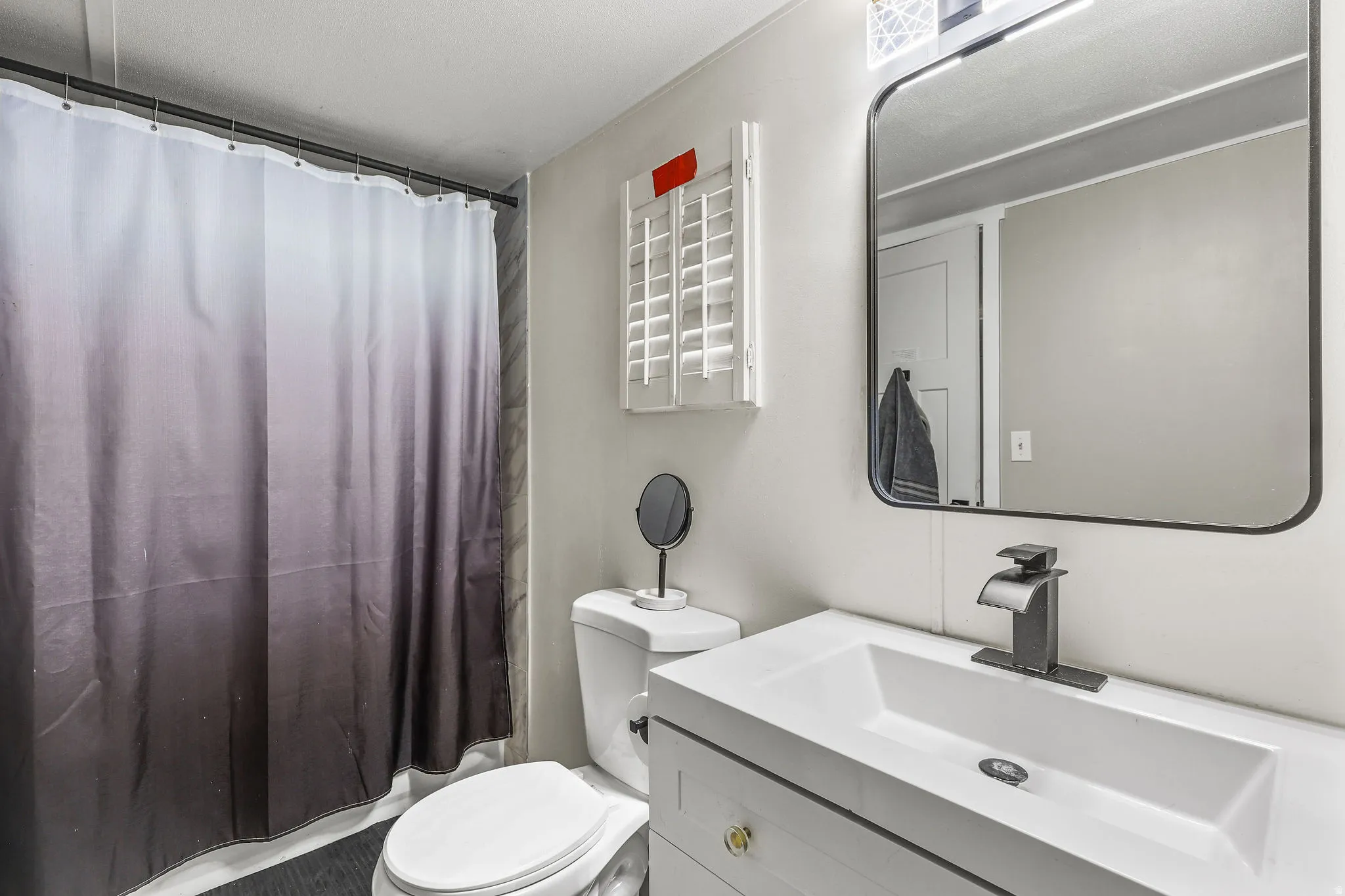 Bathroom with vanity and shower / bath combination with curtain