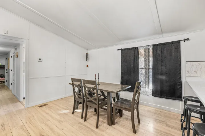Dining space featuring vaulted ceiling and light wood-type flooring