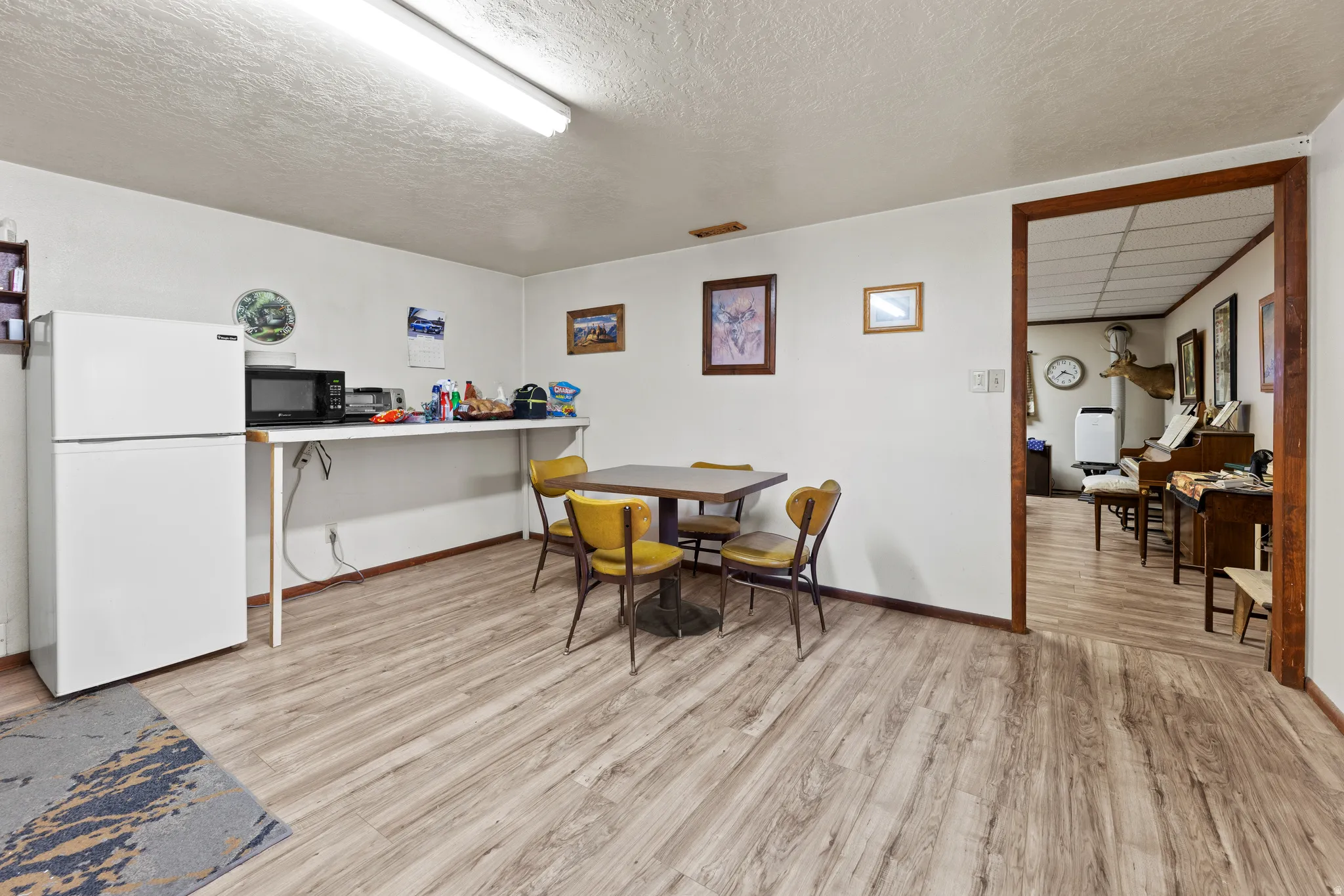 Dining space with light wood-style flooring and a textured ceiling