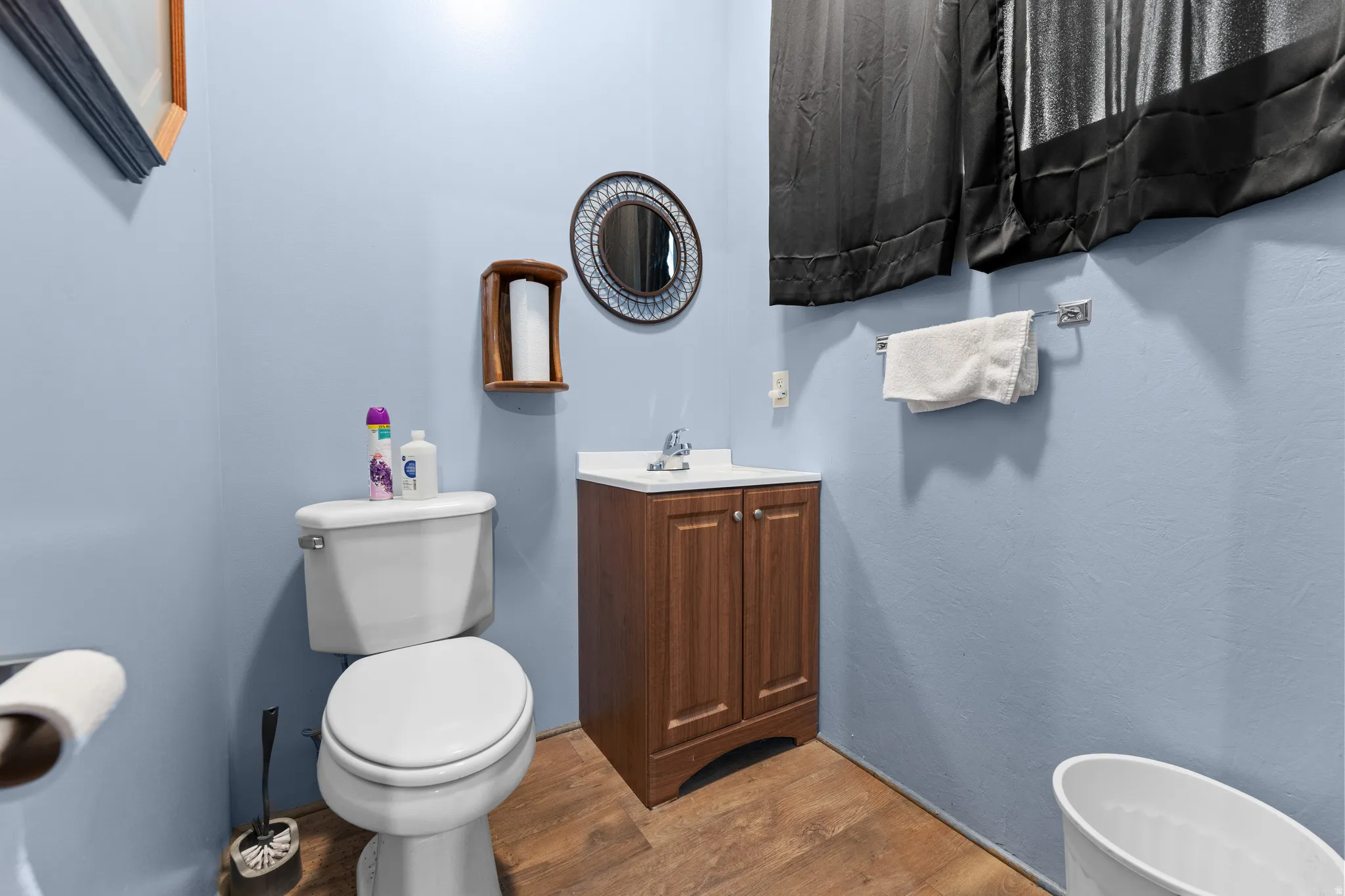 Half bathroom featuring vanity and wood finished floors