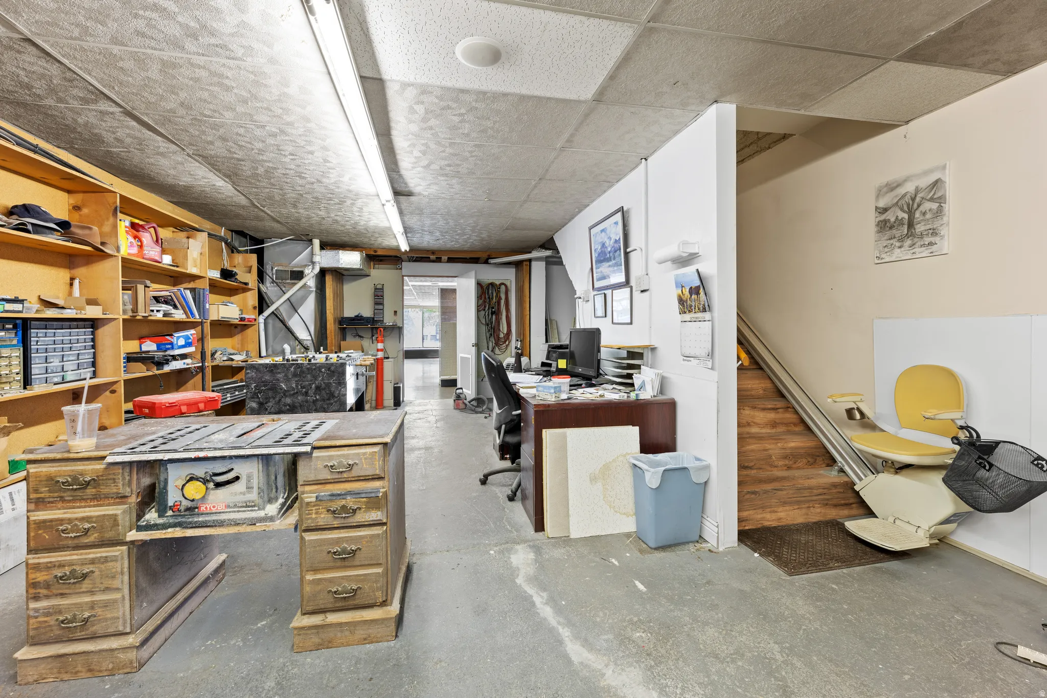 Home office with concrete flooring and a paneled ceiling