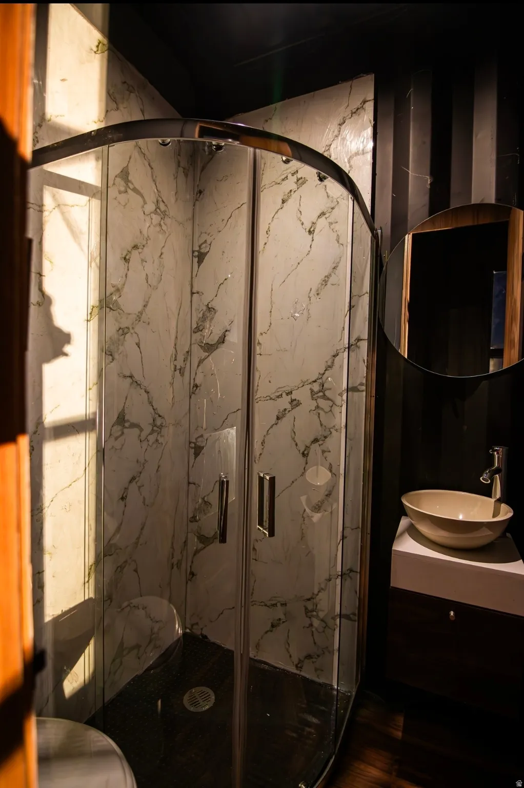 Bathroom with vanity and a marble finish shower