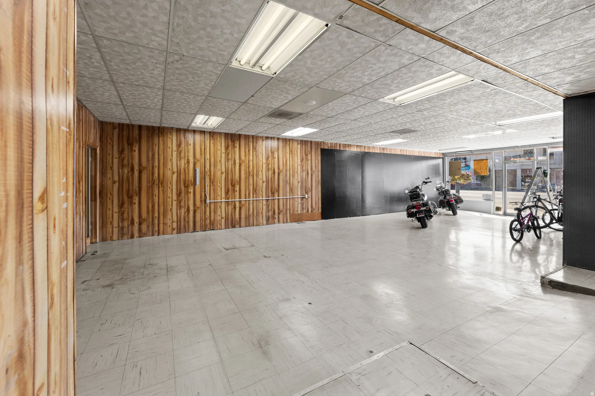 Misc room with wood walls and a drop ceiling