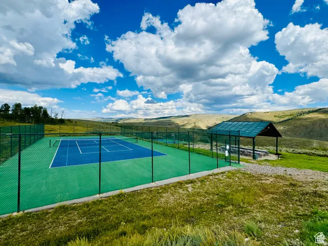 View of tennis court featuring a patio area and a mountain view