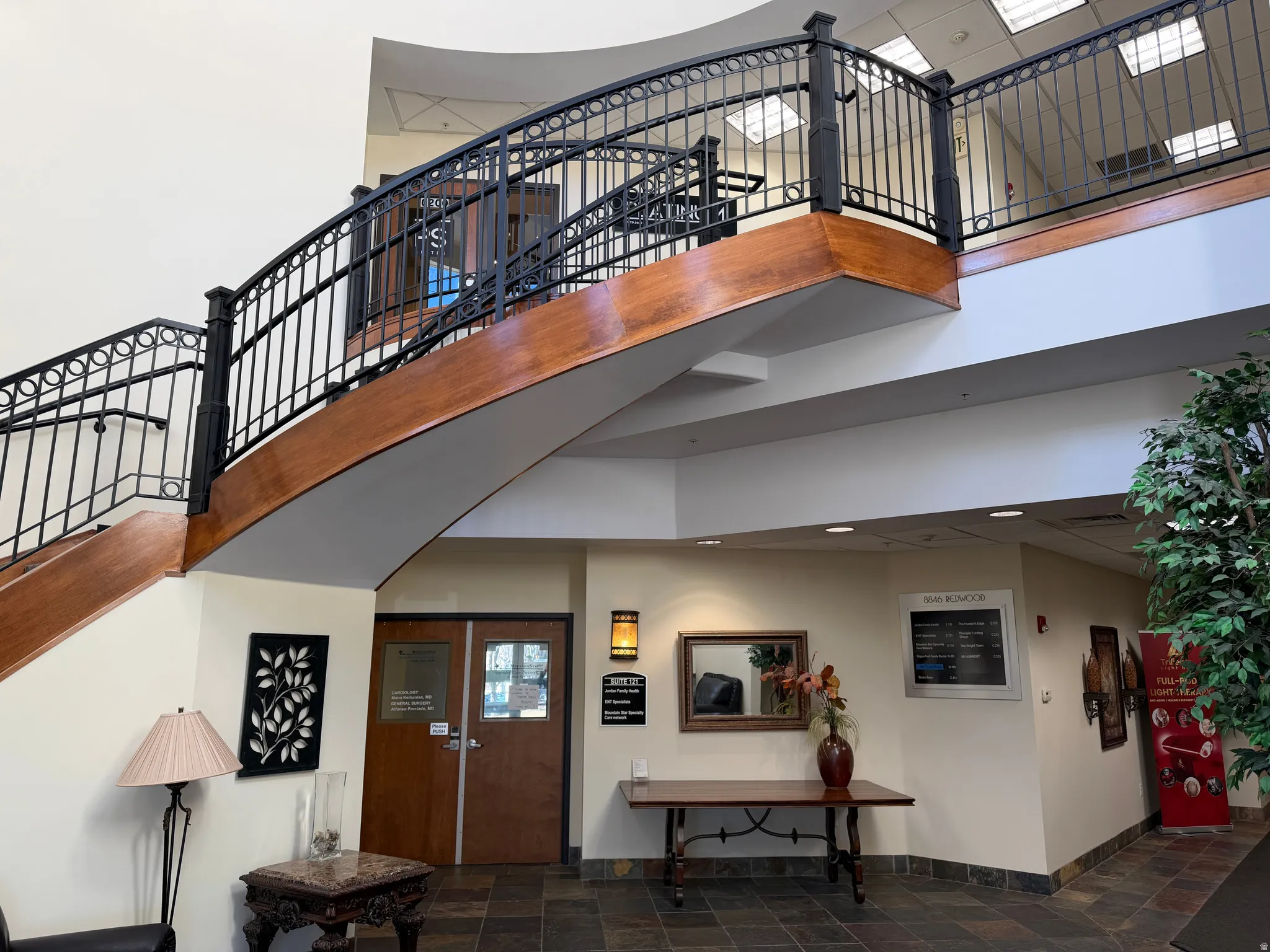 Entrance foyer featuring a high ceiling, stone finish floors, and stairway