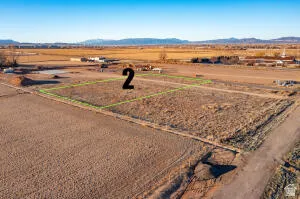Aerial view of sparsely populated area featuring a mountainous background and property boundaries highlighted