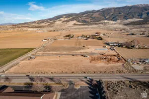 Aerial view of property and surrounding area featuring rural landscape and a mountainous background
