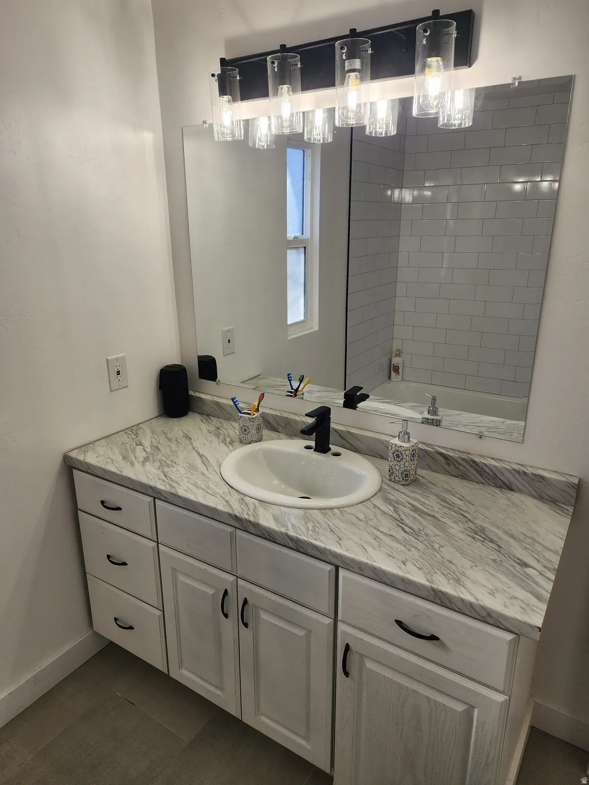 Bathroom featuring vanity and dark tile patterned floors