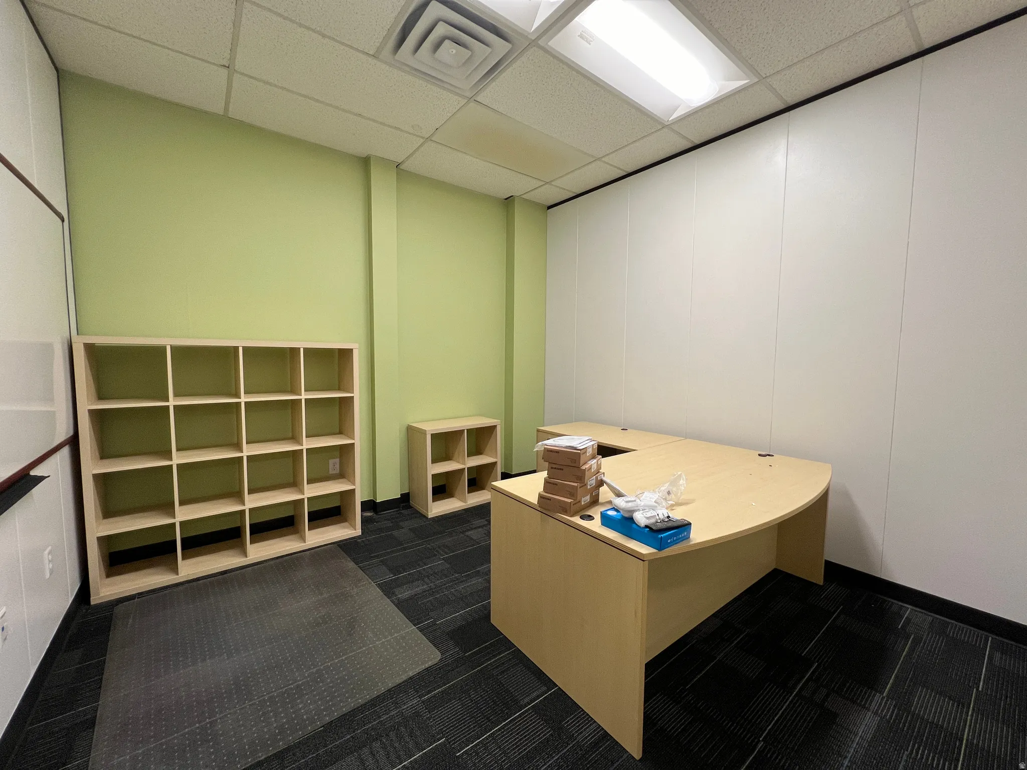 Office area with a paneled ceiling and a decorative wall